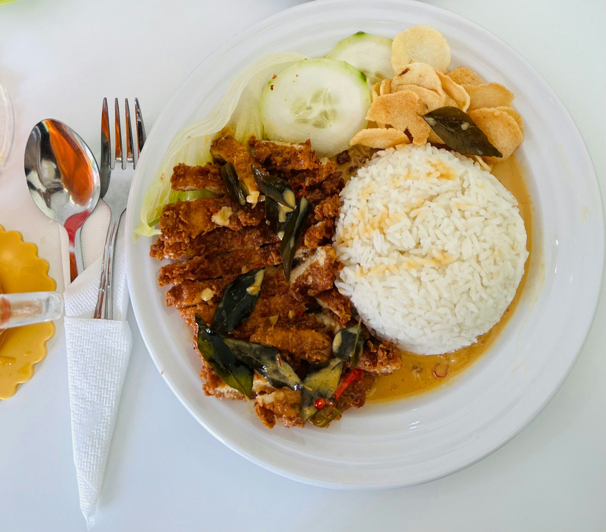 Ayam goreng tepung disiram kuah daun jeruk, disandingkan nasi putih dan kerupuk